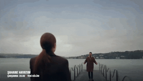 a man and a woman are standing next to a body of water with the words " sahane hayatim " written on the bottom