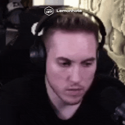 a man wearing headphones is looking at the camera and making a funny face .
