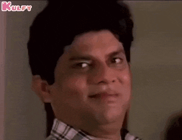 a man in a plaid shirt is making a funny face and smiling .