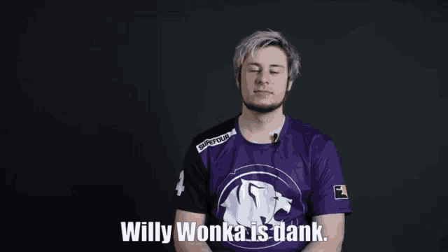 a man in a purple shirt is standing in front of a black background .