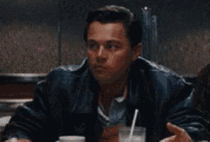 a man is sitting at a table talking to another man and says what the fuck are you talking about .