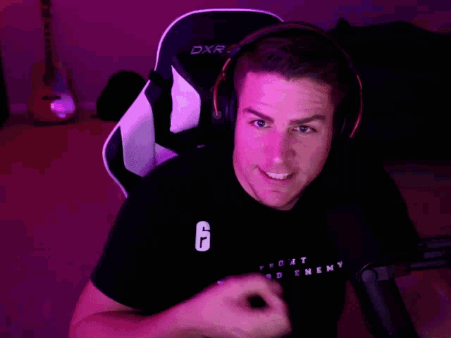 a man wearing headphones and a black shirt that says " i do n't need enemy "