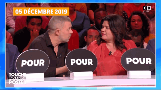 a man and a woman are sitting in front of signs that say pour