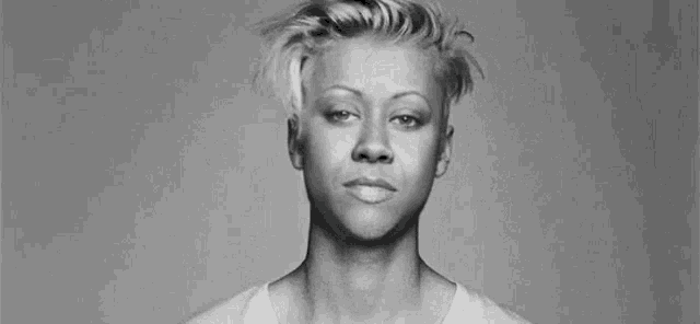 a black and white photo of a woman making a funny face .