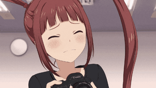 a girl is holding a canon camera in her hand