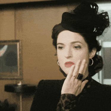 a woman wearing a black hat and a black ring