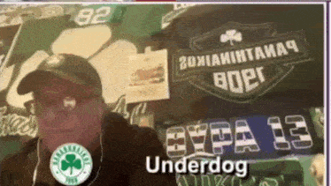 a man wearing headphones stands in front of a banner that says underdog