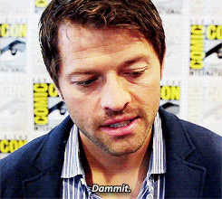 a man in a suit says " dammit " in front of comic con posters