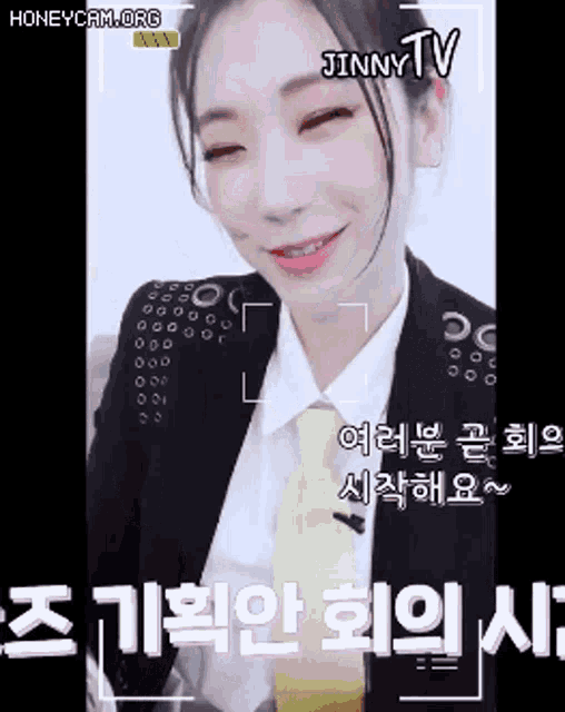 a woman wearing a suit and tie is being recorded by jinny tv