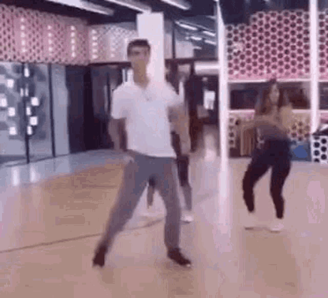 a man and a woman are dancing together on a dance floor in a gym .