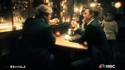 two men sitting at a bar with a nbc logo on the bottom