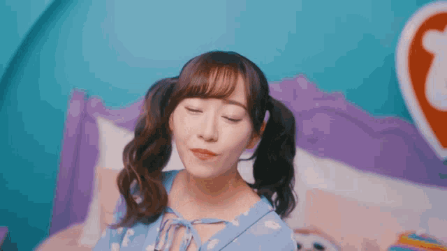 a girl with pigtails is sitting on a bed