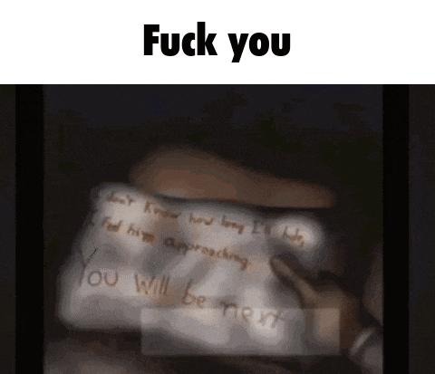 a person writing on a piece of paper that says fuck you