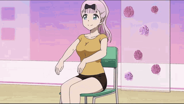 a girl in a yellow shirt is sitting in a chair with her arms outstretched