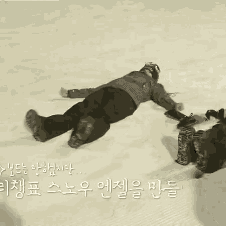 a person is laying in the snow with their arms outstretched .