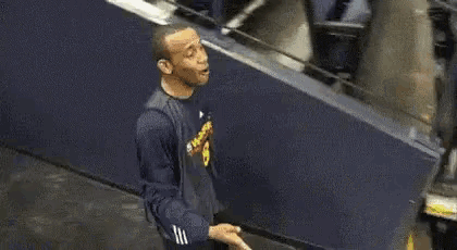 a man is standing in front of a escalator and talking to someone .