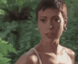 a close up of a woman 's face with her eyes closed and a blurry background .