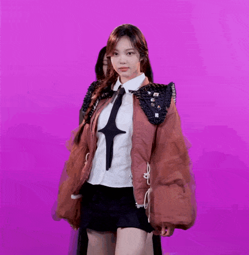 a woman wearing a jacket and tie with a cross on it