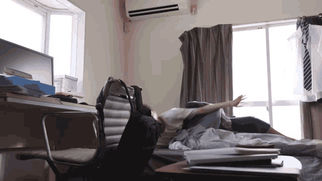 a person laying on a bed in a room with a chair