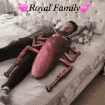 a man is laying on a bed with a stuffed cockroach on his stomach ..
