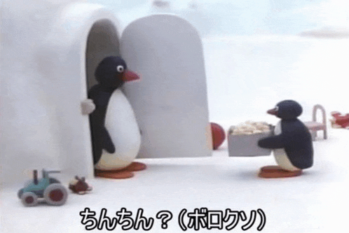 two penguins are standing next to each other in front of an igloo and one is holding a box of food .