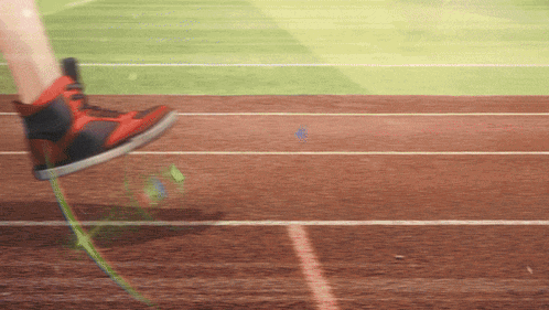 a person is running on a track wearing red and black sneakers