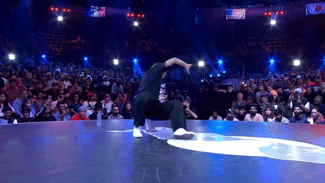 a man is dancing in front of a crowd with a sign that says ' tokyo ' on it
