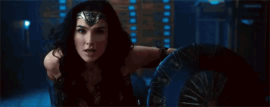 a woman in a wonder woman costume is looking at the camera .