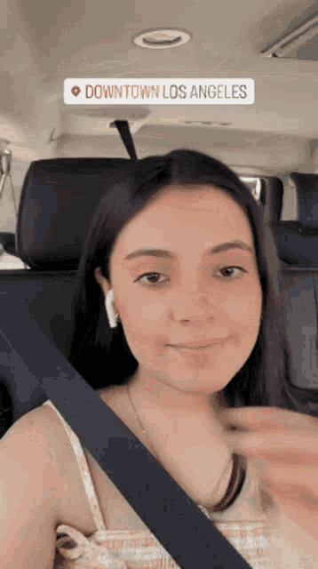 a woman in a car with a downtown los angeles sticker