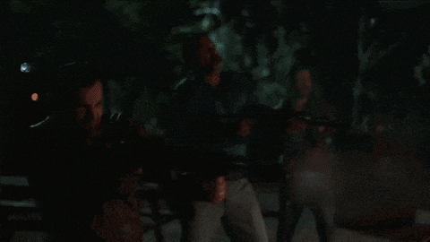 a man is holding a gun in a dark room