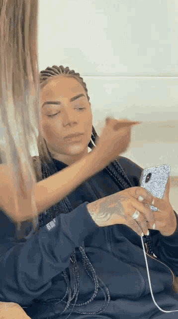 a woman applying makeup to another woman 's face