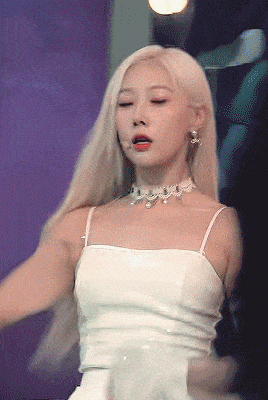 the woman is wearing a white dress and a choker .