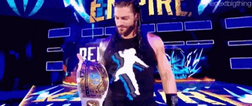 roman reigns is holding a world heavyweight championship belt while walking on a stage .