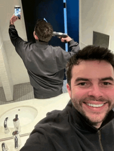 a man taking a picture of himself with a gun