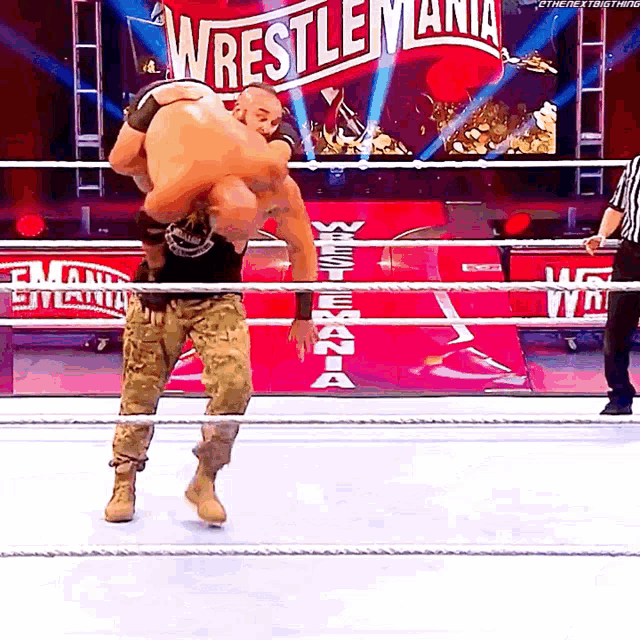 a wrestler in a ring with a sign that says wrestlemania in the background
