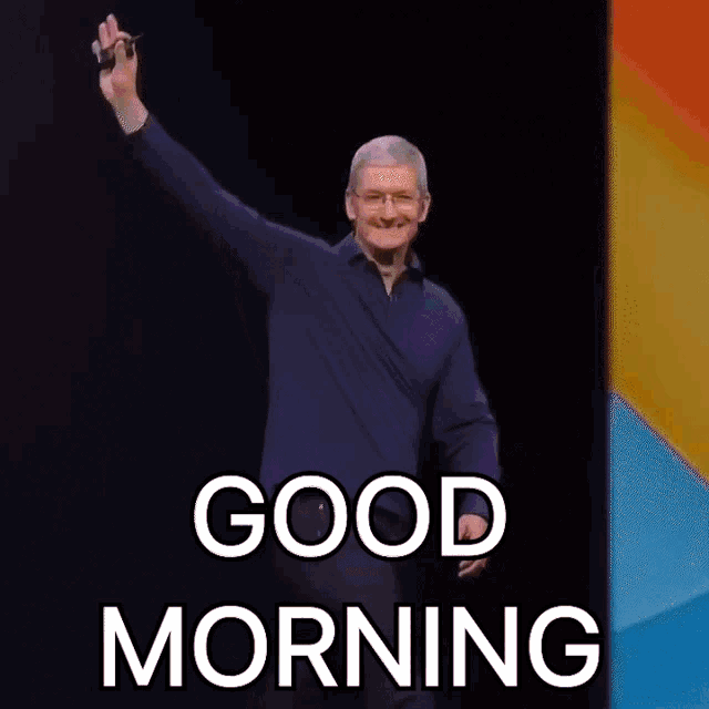 a man waving his hand in front of a sign that says " good morning "