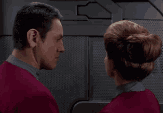 a man and a woman are touching each other 's shoulder