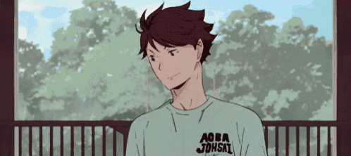 a man is standing on a balcony wearing a t-shirt that says aoba johshi .