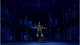 a man is standing in a room with a blue light coming out of his chest .