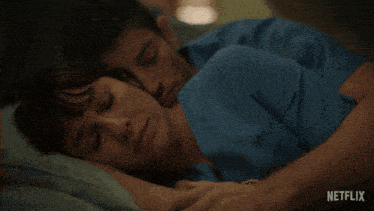 a man is hugging a woman who is sleeping in a hospital bed with the netflix logo in the corner