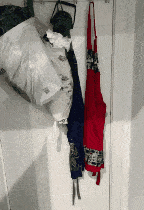 a red apron is hanging on a white wall