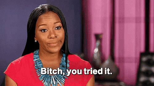 a woman is wearing a red shirt and a blue necklace and says `` bitch , you tried it '' .