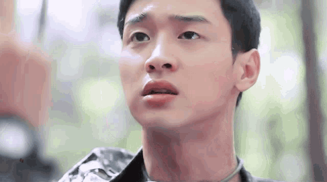 a close up of a young man 's face with a military uniform on .