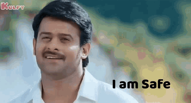 a man with a mustache and a white shirt is smiling and says `` i am safe '' .