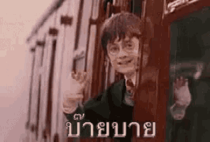 harry potter is waving from the window of a train in a foreign language .