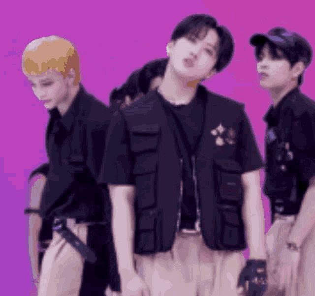 a group of young men are standing next to each other on a purple background .
