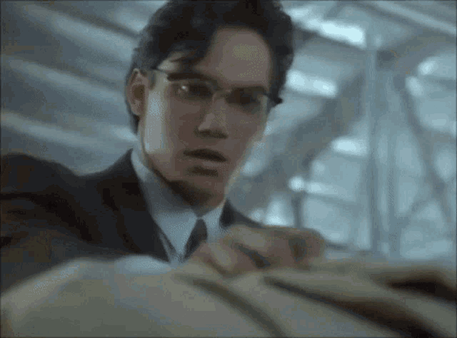 a man in a suit and tie is looking down