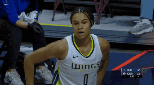 a female basketball player wearing a white jersey that says wings