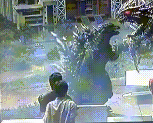 a couple of people are looking at a statue of a monster