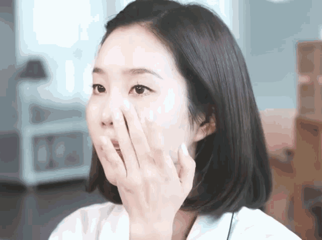 a woman is applying lotion to her face with her hand